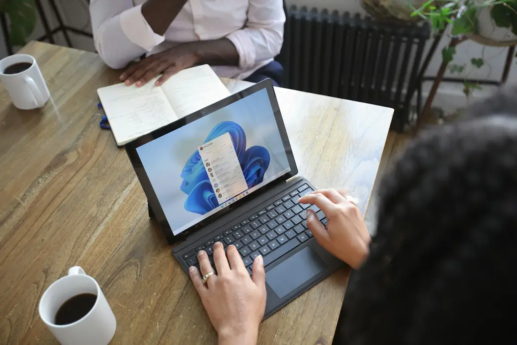 Vue plongeante d'un échange de travail autour d'une table — observation, prise de notes, accompagnement au cœur de l'audit.